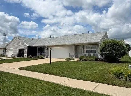 Gray ranch home with a concrete driveway and front sidewalk